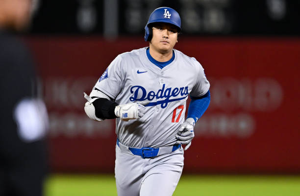 Shohei Ohtani of Los Angeles Dodgers reacts after hitting a three run homerun,his 33 homerun of the season in the bottom of the ninth inning during...