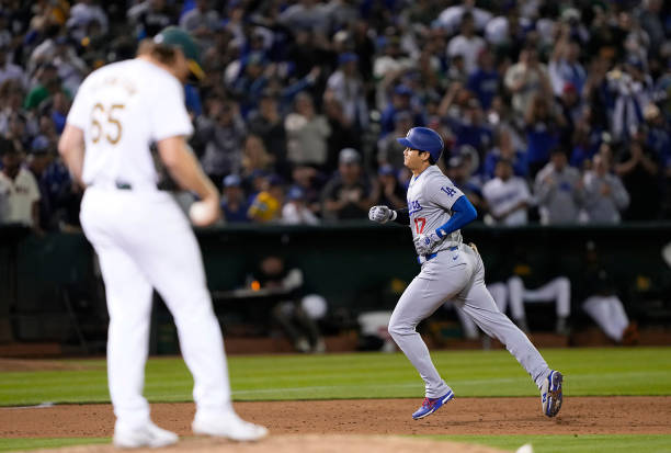 Shohei Ohtani of the Los Angeles Dodgers trots around the bases after hitting a three-run home run off of Tyler Ferguson of the Oakland Athletics in...