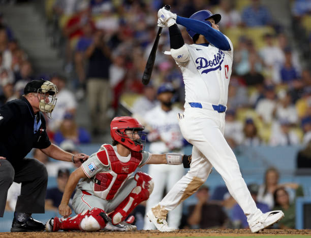 Shohei Ohtani of the Los Angeles Dodgers hits a solo home run in front of Garrett Stubbs of the Philadelphia Phillies, to take a 5-3 lead, during the...