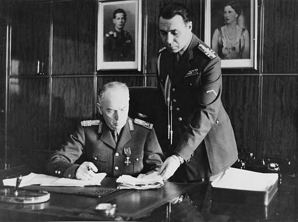 Antonescu Ion Offizier und Politiker R am Schreibtisch seines Arbeitszimmers rechts Adjutant Oberst Olefterescu im Hintergrund die Bilder von König...