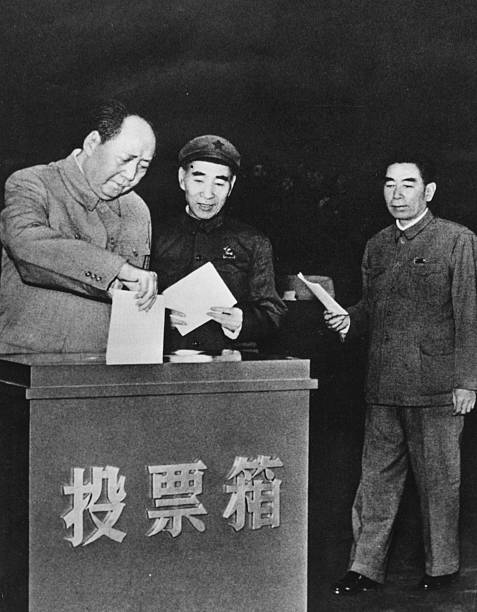 Chairman Mao TseTung of China posting his vote in a ballot box followed by Lin Biao and Zhou Enlai circa 1950