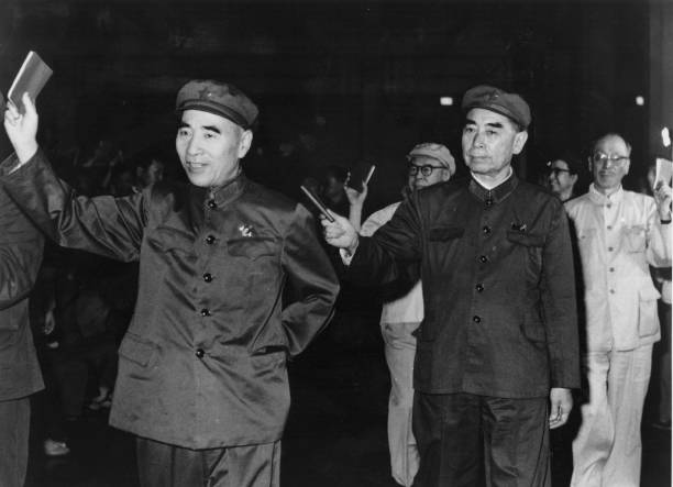 Communist Chinese leaders demonstrate their allegiance to Mao by holding quotations aloft They are in the front row left to right Len Biao president...