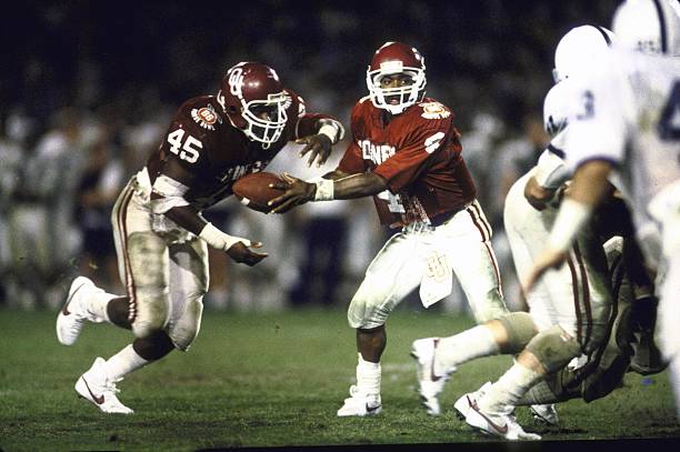 Oklahoma QB Jamelle Holieway (4) in action, handoff to teammate Lydell Carr (45) vs Penn State. Miami, FL 1/1/1986