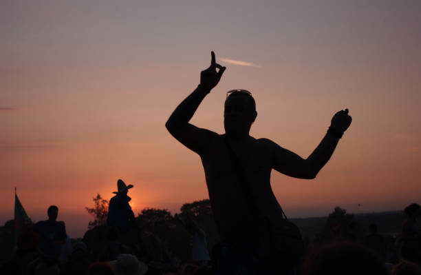 Dancer silhoueted against the setting sun at Glastonbury, 23rd June 2005.