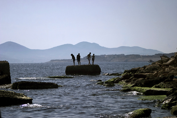 Refugees and Migrants bathe next to the port of Piraeus