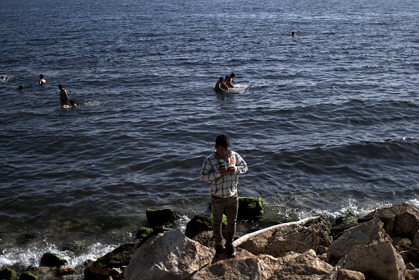 Refugees and Migrants bathe next to the port of Piraeus