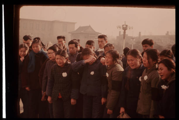 A group of mourners stand together in grief as they wait their turn to see the body of Premier Chou En Lai January 13 1976 in Peking China EnLai was...