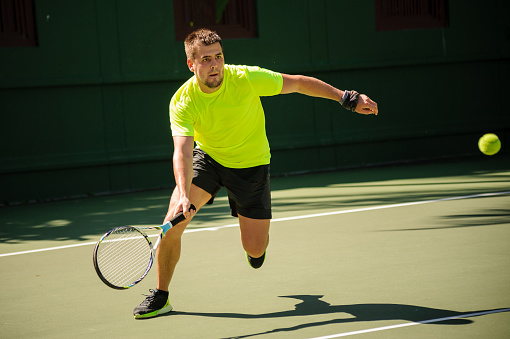 Man plays tennis in bright cloth : Stock Photo