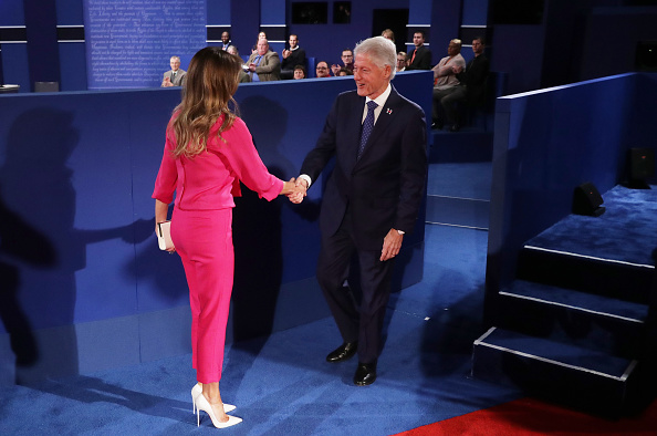 Melania Trump shakes hands with former US President Bill Clinton before the town hall debate at Washington University on October 9 2016 in St Louis...