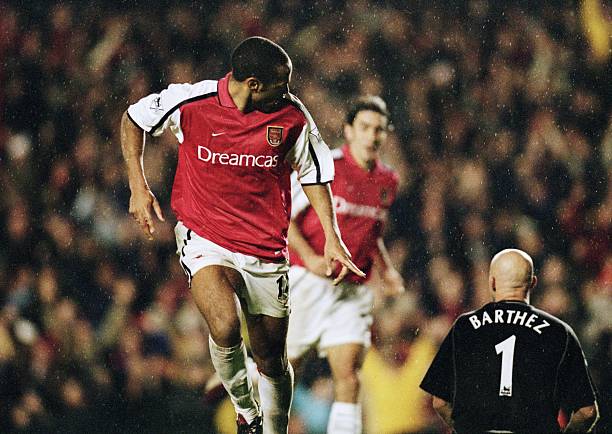 nov-2001-thierry-henry-of-arsenal-scores-as-fabien-barthez-of-united-picture-id969047