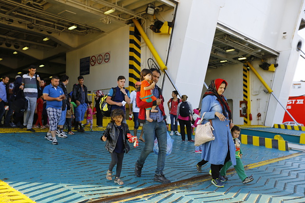 Refugees disembark from the El Venizelos ferry that has...