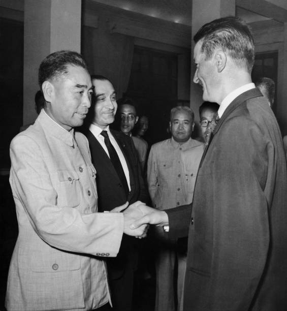 The Chinese Prime Minister ZHOU ENLAI shaking hands with the French deputy Roland DUMAS during a reception in Peking on August 10 1958