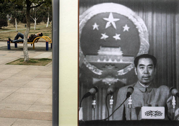 A visitor rests beside a picture featuring late Chinese premier Zhou Enlai delivering a speech during a photo exhibition on the life of Zhou to mark...