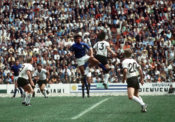 1970 World Cup Semi-Final, Mexico City, Mexico 17th June, 1970. Italy 4 v West Germany 3. West German player Gerd Muller jumps for the ball with an Italian defender as teammates Uwe Seeler (9) and Jurgen Grabowski (20) look on during the two teams&#039; semi- : News Photo