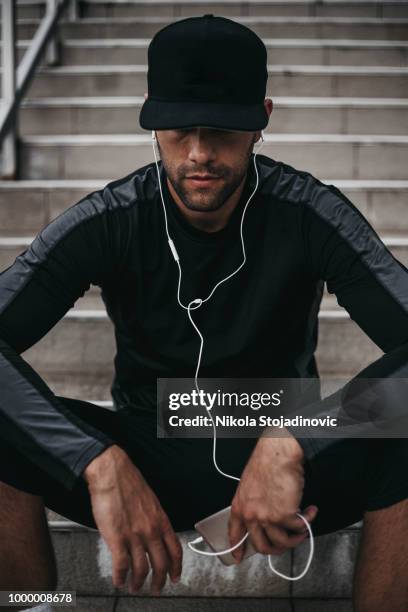 hombre joven preparándose para el entrenamiento - gorra fotografías e imágenes de stock