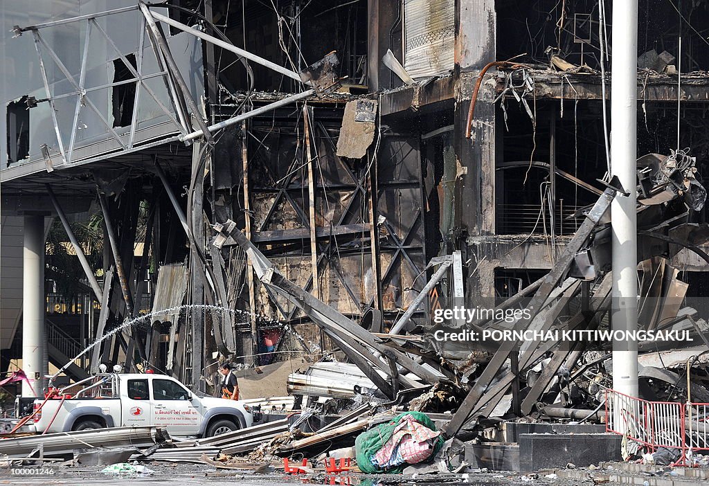 Thai firemen spray water at the site of