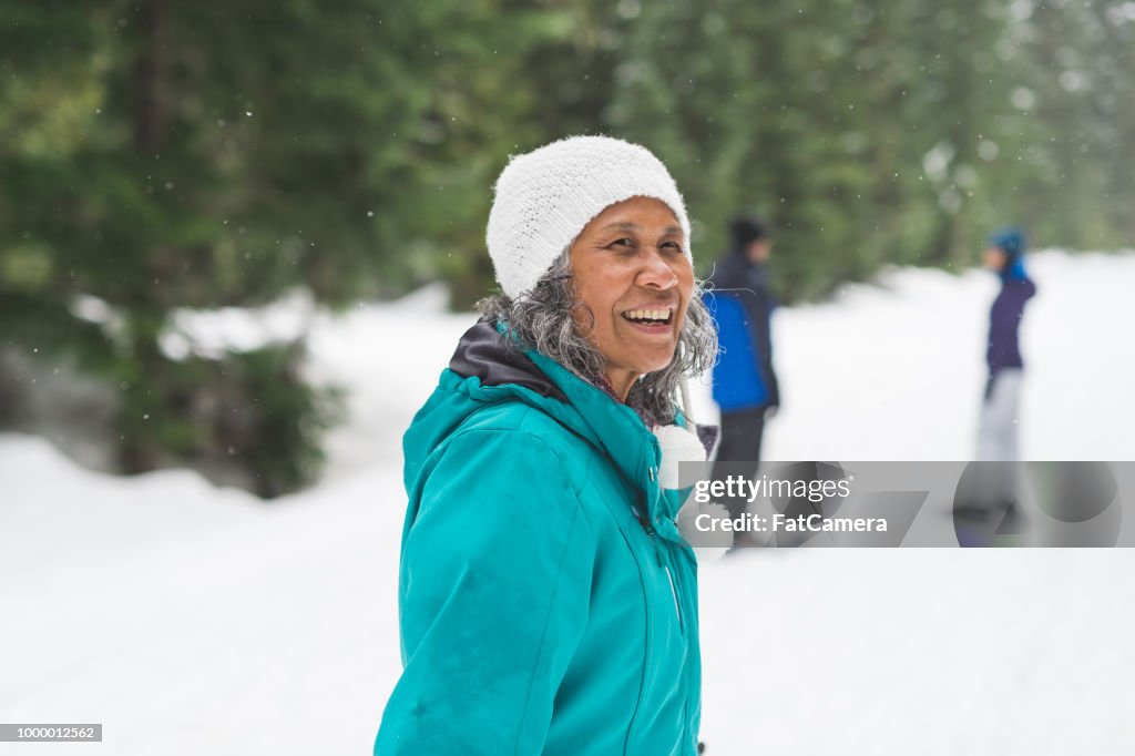 Retrato de una mujer senior con raquetas de nieve