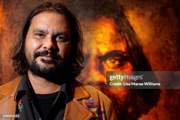 Australian director Warwick Thornton stands in front of a painting by artist Craig Ruddy after it being announced the winner of the Archibald...