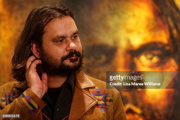 Australian director Warwick Thornton stands in front of a painting by artist Craig Ruddy after it being announced the winner of the Archibald...