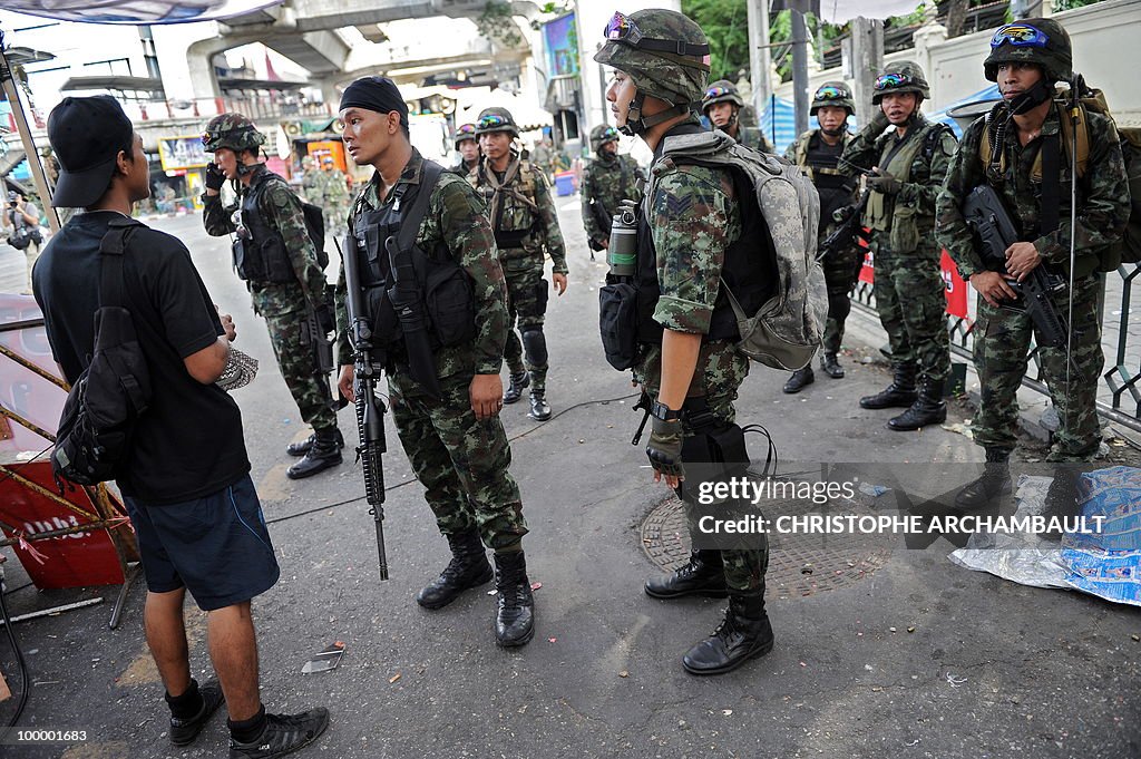 A man talks with soldiers as they make t