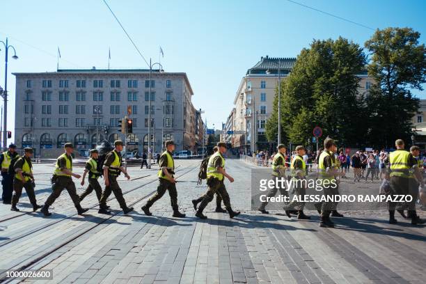 Military and police personnel walk around the area of the Finnish Presidential palace in Helsinki, Finland on July 16 hours ahead of the meeting...