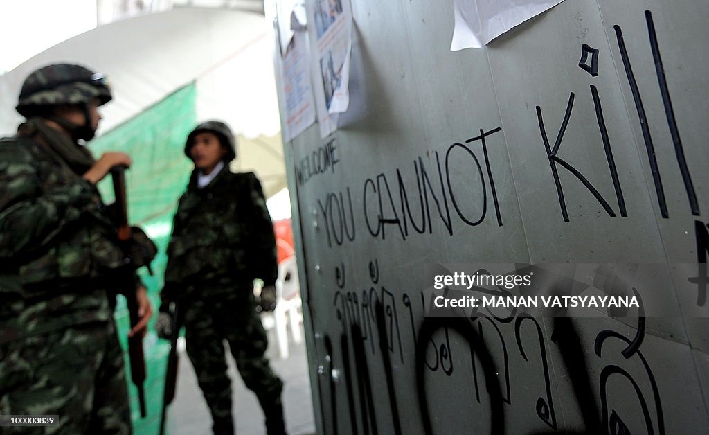 Thai soldiers stand guard next to a graf