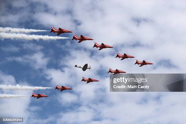 The Red Arrows fly in formation around another aeroplane at the Farnborough Airshow on July 16, 2018 in Farnborough, England. Theresa May opened the...
