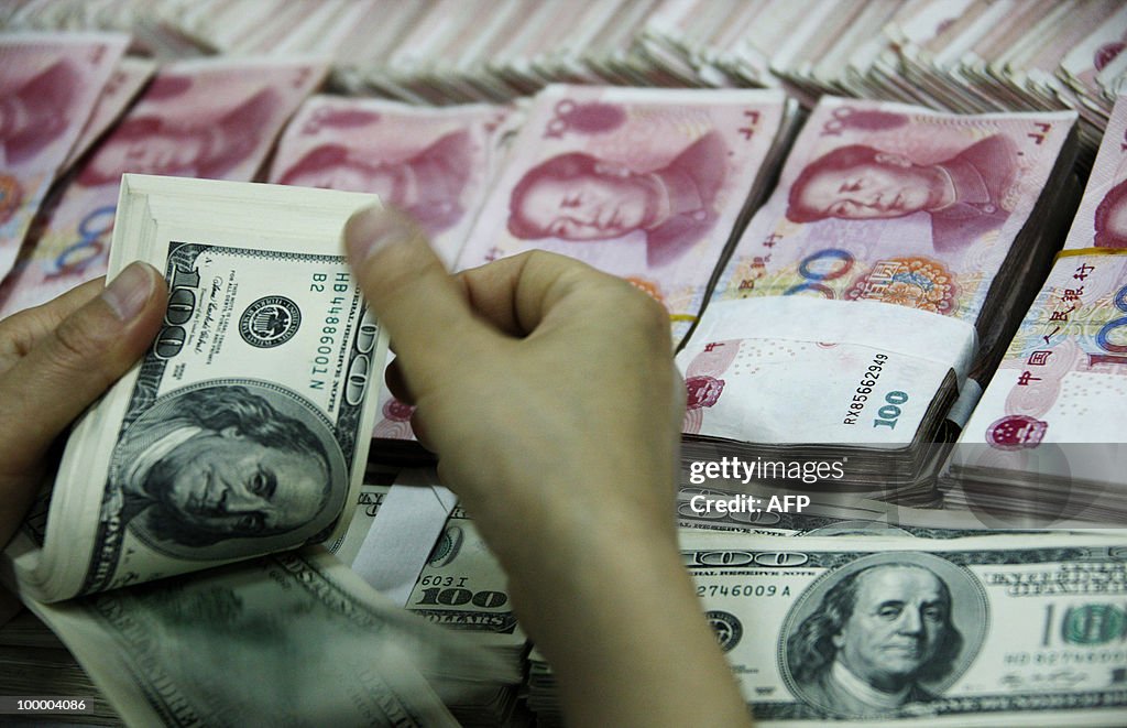 A bank clerk counts a stack of USD toget