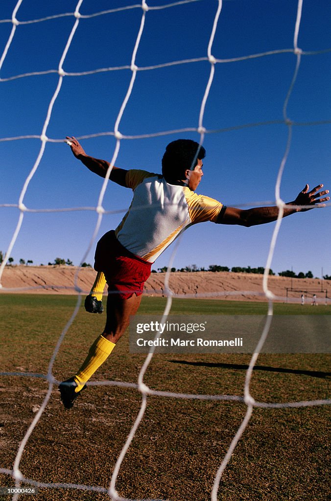 SOCCER PLAYER VIEWED THRU NET