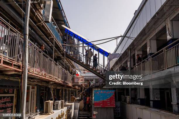 People climb a flight of stairs at the money exchange market in Kabul, Afghanistan, on Thursday, July 12, 2018. U.S President Donald last year said...