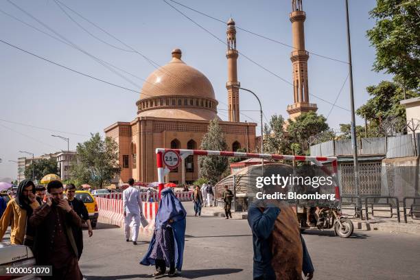 Pedestrians walk past the Abdul Rahman Mosque in Kabul, Afghanistan, on Thursday, July 12, 2018. U.S President Donald last year said 16,000 U.S....