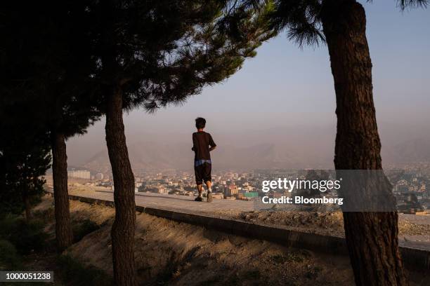 Boy runs along a wall at the top of Bibi Mahru Hill in Kabul, Afghanistan, on Sunday, July 15, 2018. Photographer: Jim Huylebroek/Bloomberg via Getty...