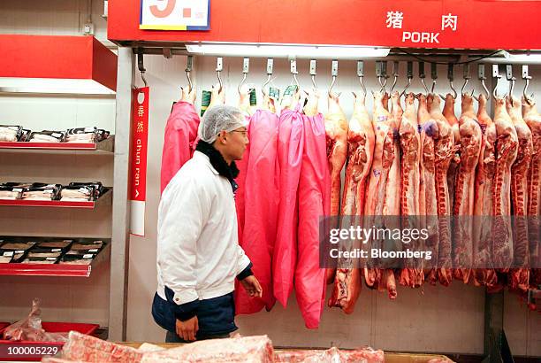 Staff member works in the meat section of a Metro AG supermarket in Shanghai, China, on Wednesday, May 19, 2010. Metro AG, Germany's largest...