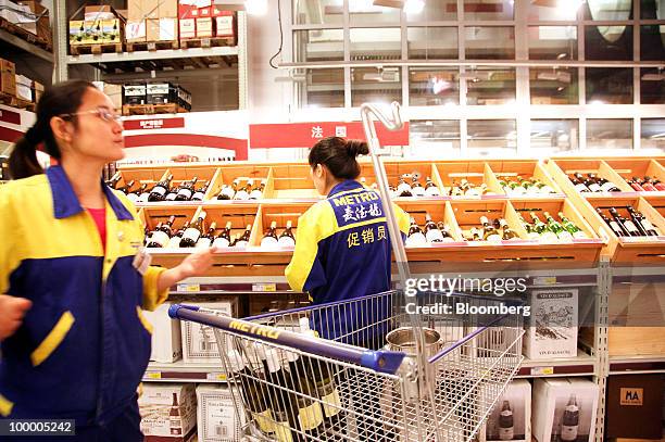 Staff members work in the wine section at a Metro AG supermarket in Shanghai, China, on Wednesday, May 19, 2010. Metro AG, Germany's largest...