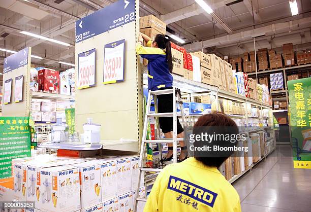 Staff members work at a Metro AG supermarket in Shanghai, China, on Wednesday, May 19, 2010. Metro AG, Germany's largest retailer, plans to add 100...