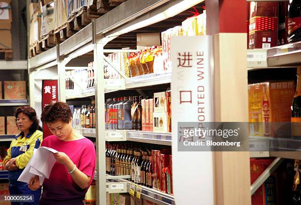 Staff members work in the imported wine department at a Metro AG supermarket in Shanghai, China, on Wednesday, May 19, 2010. Metro AG, Germany's...