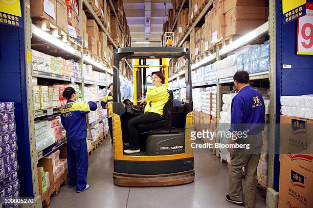 Staff members work at a Metro AG supermarket in Shanghai, China, on Wednesday, May 19, 2010. Metro AG, Germany's largest retailer, plans to add 100...