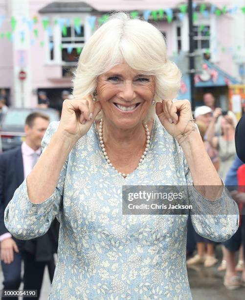 Camilla, Duchess Of Cornwall holds her ears as a small cannon is fired as she attend the Fowey Festival Celebration with Prince Charles, Prince Of...