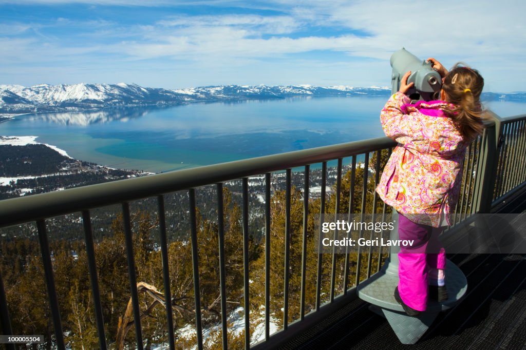 Girl looking through a telescope at Lake Tahoe