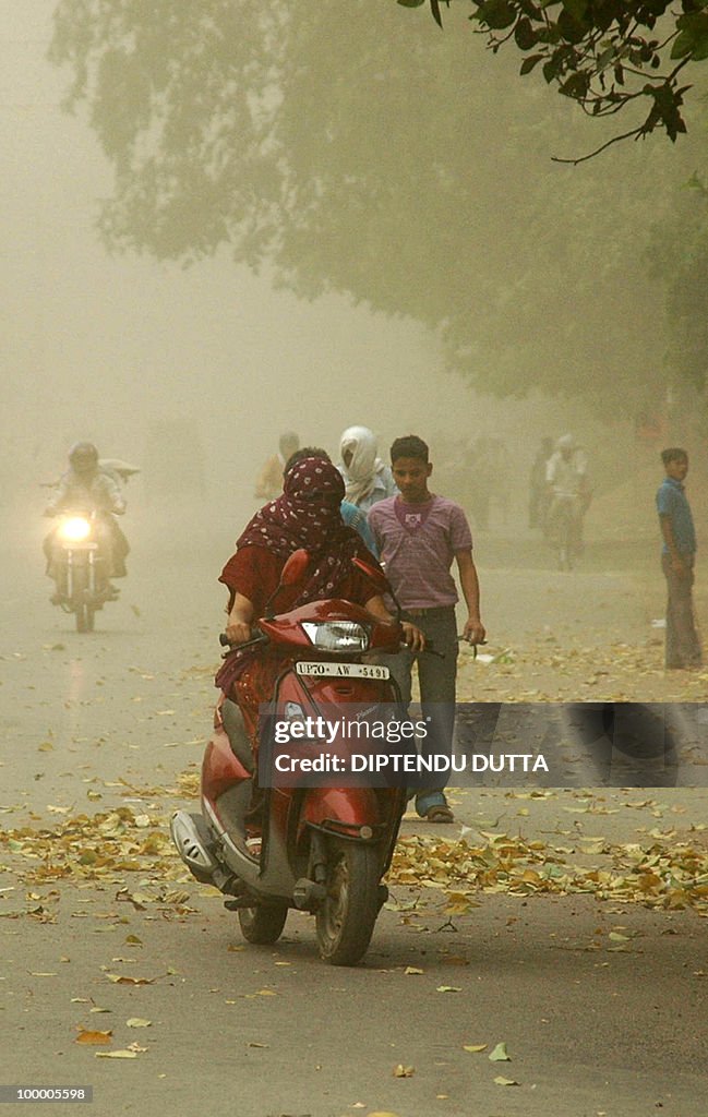 Indian commuters journey through a dust