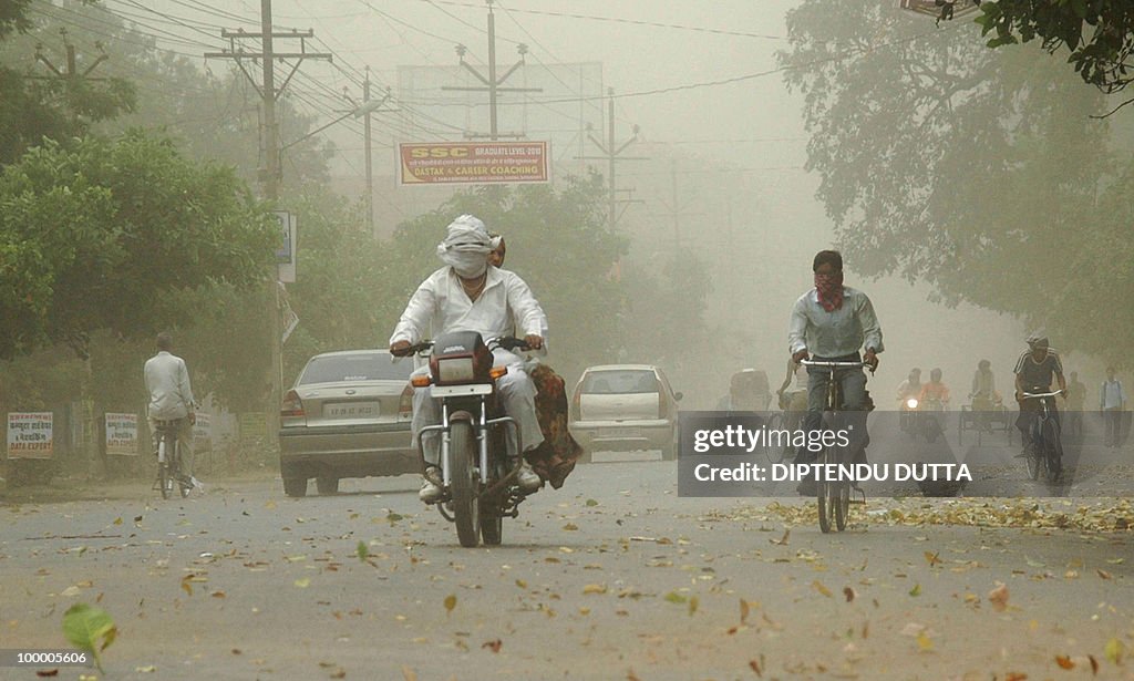 Indian commuters journey through a dust