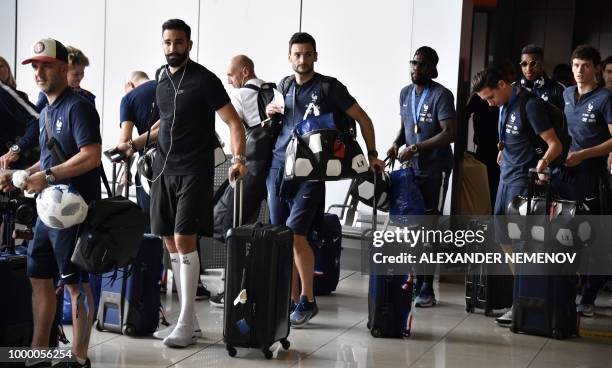 France's defender Adil Rami, goalkeeper Hugo Lloris, defender Samuel Umtiti, forward Florian Thauvin and defender Benjamin Pavard depart home from...