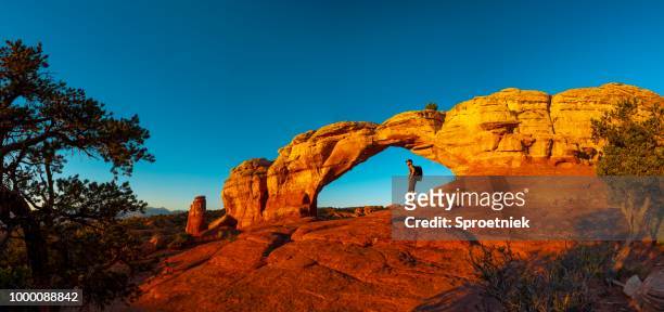 escursionista a riposo nell'arco della torretta - moab foto e immagini stock