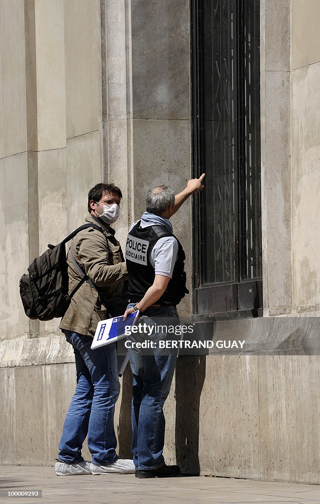 A policeman (R) shows to an investigator