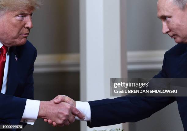 President Donald Trump and Russian President Vladimir Putin shake hands ahead a meeting in Helsinki, on July 16, 2018.