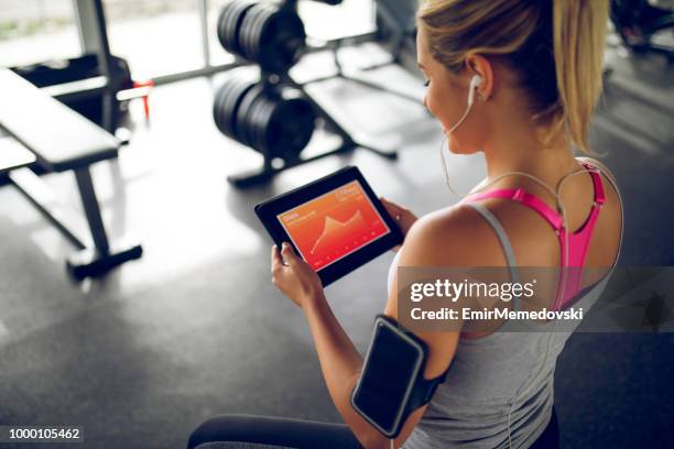 haar voortgang met fitness app op digitale tablet - sport tablet stockfoto's en -beelden