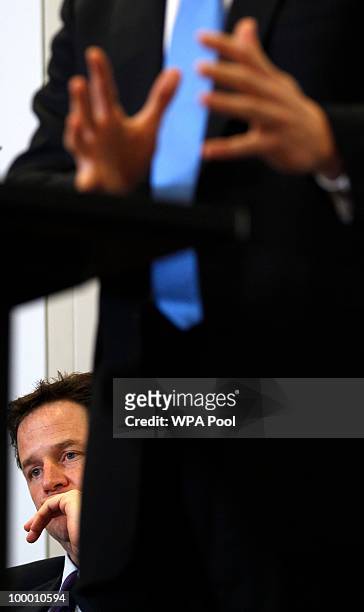 Britain's Deputy Prime Minister Nick Clegg listens to Britain's Prime Minister David Cameron during the launch of the Government Programme Coalition...