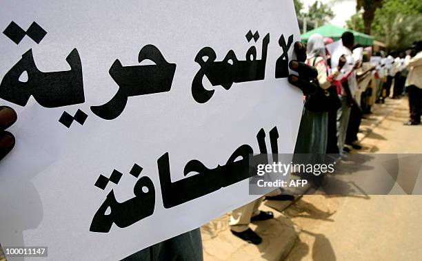 Sudanese holds up a placard that reads "No to the oppression of press freedom" during a protest against the storming by security forces of two...