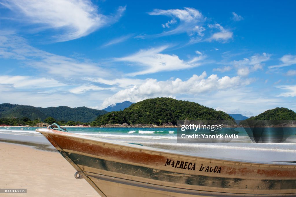 A fisher boat stationed in the sand in a sunny day in Ubatuba, Sao Paulo