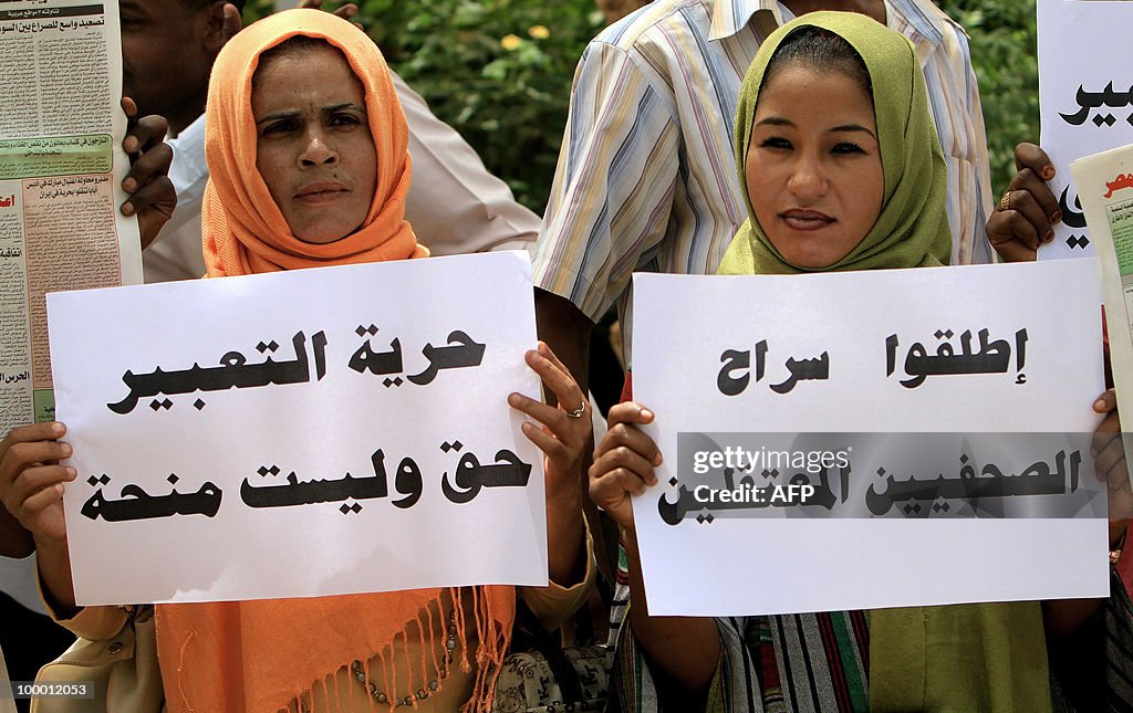 Two Sudanese women hold up placards that